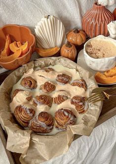 there is a pie with icing on it next to some pumpkins and other decorations