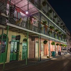 an old building with balconies and plants on the balcony at night in new orleans