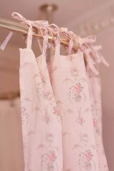 pink floral curtains hanging from a metal rod