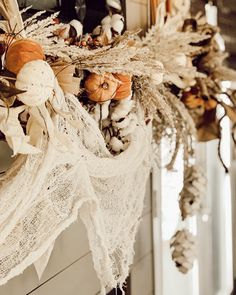 dried flowers and leaves are hanging from the front door frame, along with other autumn decorations