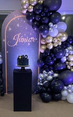 there is a cake and balloons in front of the backdrop that says junior on it