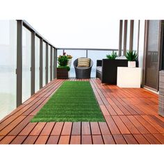 an outdoor deck with grass and potted plants