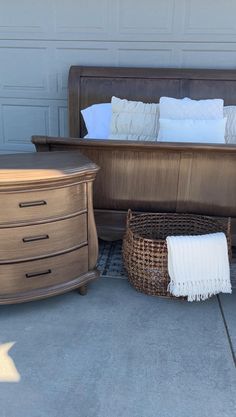 a bed sitting next to a dresser on top of a cement floor