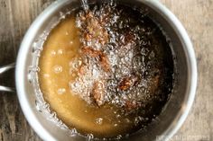 a pot filled with liquid sitting on top of a wooden table