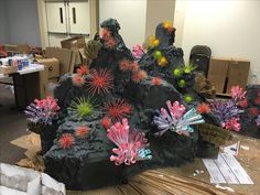 some fake flowers and rocks in an office cubicle with other items on the floor