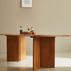 a wooden table sitting in the middle of a room next to a chair and framed photograph