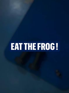 a blue cutting board with the words eat the frog on it's bottom corner