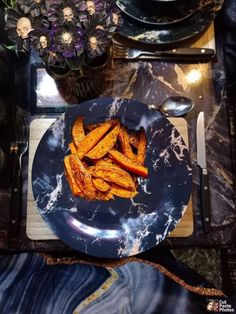 a plate with some food on it next to a flower pot and utensils