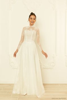 Our sweet and stylish Calixta white bridal ao dai is the perfect ensemble for modern brides who love a whimsy, girly aesthetic. Calixta features a flare A-line bottom, sheer, couture French lace detailing, silk pants, and a classic high collar. This gorgeous, romantic ao dai is the ideal fusion of traditional and modern elements. Feel unique, classy, and elegant in Calixta! Detail: White Vietnamese Ao Dai Collar: 1.2''/3cm Long sleeves Bra cups added Zipper closure Flare A-line bottom Floor len White Bridal Ao Dai, Gold Ao Dai Wedding, Vietnamese Wedding Ao Dai, Lace Ao Dai, Vietnamese Wedding Dress, Vietnamese Wedding, Bridal Robes, White Bridal, French Lace