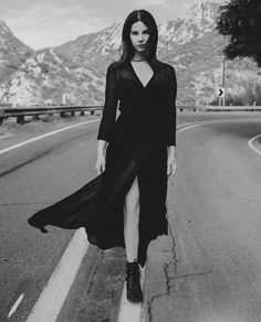 black and white photograph of woman in long dress on road