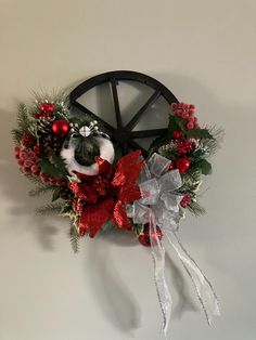 a christmas wreath hanging on the wall in front of a clock with bells and decorations