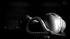 a black and white photo of a boxing glove with a rope wrapped around the handle