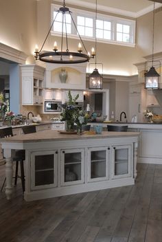 a large kitchen with an island in the middle and lots of lights hanging from the ceiling