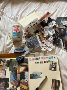 an open notebook sitting on top of a bed covered in pictures