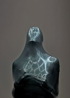 a statue is shown in the dark with light coming from it's head and shoulders