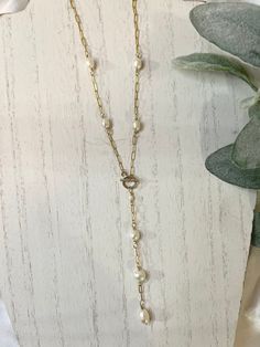 14k Gold Filled Lariat Necklace, Y-Pearl Long Necklace, Dainty Gold Paperclip Chain Necklace, Delicate Pearl Drop Necklace, Pearl Wedding Jewelry ✨ Show off your bold, sophisticated side with this dainty Y-pearl Lariat necklace. This beautiful long chain necklace is made with freshwater pearls and high quality & hypoallergenic 14K Gold Filled.  PRODUCT SPECIFICATIONS: ✨14 Karat High Quality Gold Filled Chain ✨ 14 Karat High Quality Gold Filled Wire & Toggle Clasp ✨Freshwater Pearls ✨16" with a 3.5" chain and pearl drop  This piece is:  -Hypoallergenic  -Tarnish-free -Waterproof  -High Quality  WHAT IS GOLD FILLED? Gold filled is a layer of real gold that is 100 times thicker than gold plated and bonded to the base metal. Gold Filled metal is hypoallergenic, tarnish resistant, as well as du Classic Lariat Pearl Necklace With Adjustable Chain, Formal Pearl Lariat Necklace, Classic Pearl Chain Lariat Necklace For Formal Occasions, Formal Pearl Drop Lariat Necklace, Formal Lariat Jewelry With Pearl Drop, Formal Adjustable Lariat Necklace With Pearl Drop, Gold Backdrop Necklace With Pearl Charm For Wedding, Delicate Gold Pearl Lariat Necklace, Formal Gold Pearl Lariat Necklace