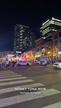 a busy city street at night with cars and people