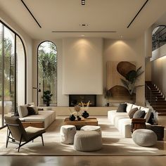 a living room filled with lots of furniture next to tall glass windows on the wall