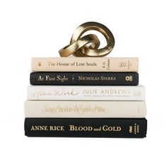 three books stacked on top of each other, one with a gold ring on top