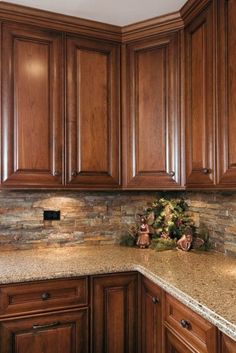 a kitchen with wooden cabinets and granite counter tops in the center is decorated for christmas