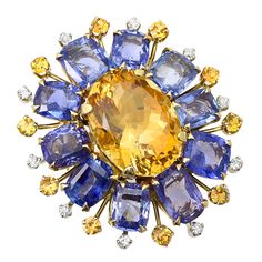 A bold floral ring centered with a large mixed cut oval shape citrine clustered with ten natural, no heat square cushion shape blue sapphires spaced with ten stems hosting yellow sapphires and accented with ten round brilliant-cut diamonds; size 6 1/4 US Bulgari Ring, Vintage Cocktail Ring, Citrine Jewelry, Floral Ring, Diamond Cocktail Rings, Floral Retro, Expensive Jewelry, Citrine Ring, Buying Diamonds