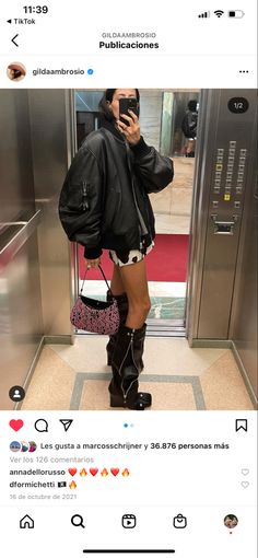 a woman standing in front of an elevator taking a selfie