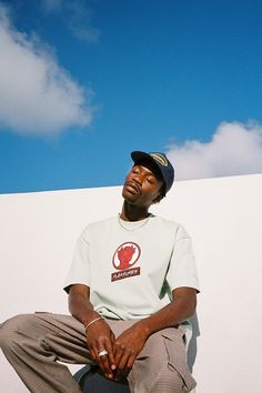 a man sitting on top of a white wall