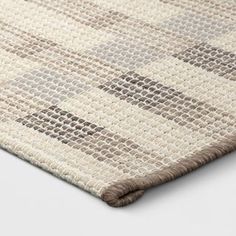 an area rug with brown and beige squares on it's side, in the middle of