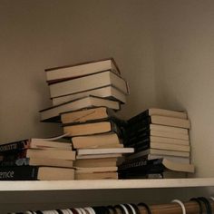 a stack of books sitting on top of a white shelf