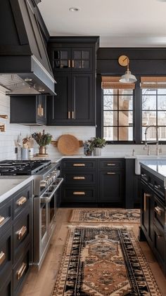 a kitchen with black cabinets and an area rug on the floor in front of the stove