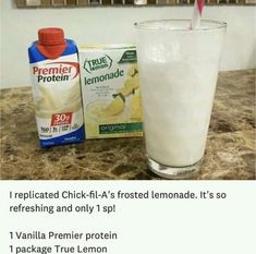 a glass with milk and a carton of lemonade next to it on a counter