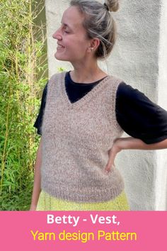 a woman standing in front of a wall with her hands on her hips and the words betty - vest, yarn design pattern