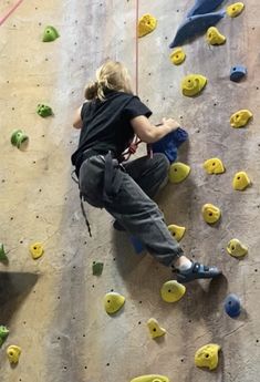 a woman climbing up the side of a rock wall