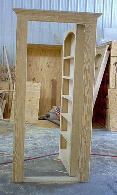 an unfinished wooden bookcase in the shape of a door