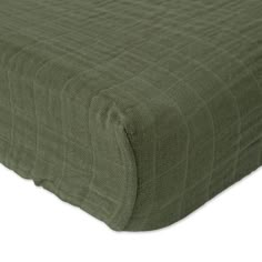 the coverlet is made from green fabric and has a square pattern on it,