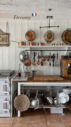 a kitchen with pots and pans hanging on the wall