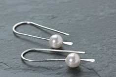 Simple, pretty, minimalist threader earrings in Sterilng Silver wire with white Swarovski pearls. These earrings are hand formed sterling silver ear wires that have a hammered paddle end.  The earrings hang 1 1/4 inches (3.1 cm) long. Made with Argentium Sterling Silver that is bright and tarnish resistant. These Pearl beads are Swarovski made in Austria. **Also available in silver with rose gold, and grey pearls. All earrings come with clear earring stoppers. All of my designs are created by me Wedding Earrings Silver, Silver Earrings Wedding, Blue Gemstone Earrings, Silver Threader Earrings, Clear Earrings, Hammered Sterling Silver, Hammered Gold, June Birthstone, Earrings Wedding