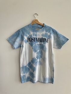 a blue and white t - shirt with the word post marine on it hanging from a hanger