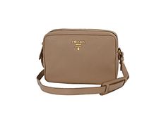 This crossbody bag is crafted with beige vitello phenix leather. The bag features a gold Prada Milano logo on the front and an adjustable leather strap. The two zipper compartments open to a spacious jacquard lined interior that allows for convenient storage and organization. This Prada handbag is great for everyday use with the distinctive quality and style of Prada!    Model: 1BH079  Cammeo Beige Vitello Phenix Grain Leather  Gold-tone Hardware  Prada Milano Logo  Zipper Closure  Two Zipper Co Travel Crossbody Shoulder Bag With Gold-tone Logo Plaque, Beige Crossbody Shoulder Bag With Gold-tone Logo Plaque, Leather Shoulder Bag With Logo Plaque For Travel, Travel Leather Shoulder Bag With Logo Plaque, Luxury Shoulder Bag With Logo Plaque For Travel, Gold Crossbody Bag With Logo Plaque, Luxury Logo Plaque Shoulder Bag For Travel, Travel Crossbody Bag With Gold-tone Logo Plaque, Luxury Crossbody Bag With Logo Plaque