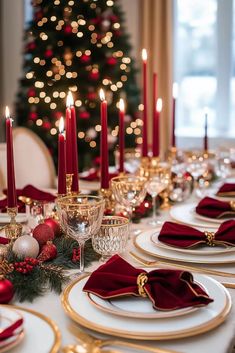 a christmas table setting with red and gold place settings