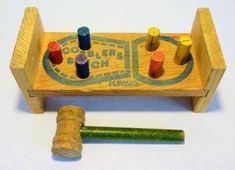 a wooden toy with some colored crayons on it