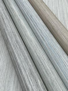 several different colors of fabric on top of each other, including grey and white stripes