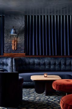 a living room filled with furniture and a blue curtained wall behind the couches