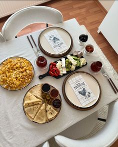 the table is set with plates, bowls and condiments for an appetizer