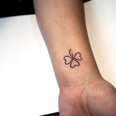 a small four leaf clover tattoo on the wrist