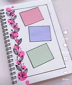 an open notebook with pink and blue paper on it next to markers, pens and pencils