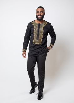 Style#M2077BLK Inspired by traditional African attire, the Karim is an essential top for a cultured gentleman. Wear this traditional gold embroidered shirt for special occasions and pair it with dress pants. For a more casual look, pair this multi-purposed shirt with jeans. Description: Embroidered neckline and cuff Button up hidden placket 2 buttons closure on the cuff Stretch poplin fabric 97% Cotton/3% Lycra Sateen Designed in the USA, imported Care Instructions Cold wash. Do not bleach. Dry Traditional Shirts For Men African, Traditional African Attire, Black And Gold Shirt, Shirt With Jeans, Nigerian Men Fashion, Latest African Men Fashion, African Shirts, African Inspired Fashion, African Men Fashion