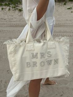 a woman carrying a white bag with the words mrs brown on it