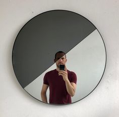 a man is taking a selfie in front of a mirror with his cell phone