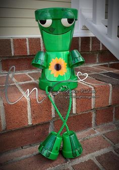 a green paper mache sitting on top of a brick wall